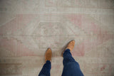 Distressed vintage Oushak runner with pale blush, beige, and sand tones underfoot.