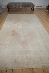 Distressed vintage Oushak rug runner with pale blush, beige, and silver stepped medallion.