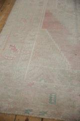 Soft, even wear and pale blush tones on the distressed pile of this vintage Oushak rug.