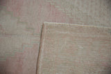 Pale blush and beige distressed Oushak rug pile with hand-knotted reverse and fringe.