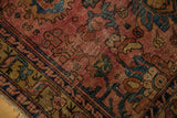 Detail of antique Lilihan rug's worn raspberry field, blue and gold palmettes, faint foundation.
