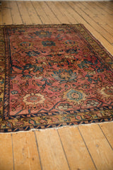 Antique Lilihan rug showing tattered edge, worn pile, and raspberry red motifs.