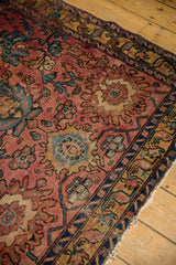 Antique Lilihan rug's tattered side, secured edge, raspberry field, and blue palmette motifs.