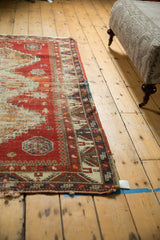 Antique Caucasian rug showing geometric pawn motif border and time-softened cherry red pile.
