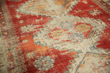 Storied wear highlights geometric pawn motif on cherry red and ivory antique Caucasian rug.
