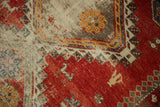 Antique Caucasian rug: cherry red field, scattered animal figures, and a geometric pawn motif.