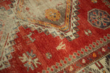 Antique Caucasian rug showing cherry red field, scattered animal motifs, and pawn design border.