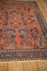 Angled view of vintage Lilihan rug's raspberry red floral field with even wear.