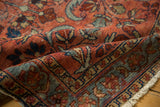Close-up Lilihan rug: raspberry red, sky blue floral patterns, visible low pile, and fringe.