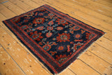 Antique Lilihan rug corner: intricate navy and madder red floral design, showing mostly even wear.