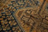 Close-up of the vintage Kamseh rug, revealing navy blue floral designs and low pile bronze geometric motifs.