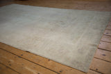 Distressed vintage Oushak carpet showing soft, worn pile texture and secured edge.