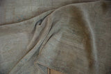 Distressed vintage Oushak rug texture highlighting soft ivory and mauve shades.