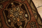 Detail of hand-knotted Oushak rug showing copper, chocolate, beige, tangerine floral motifs.