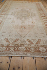 Low angle view of a distressed Oushak rug's soft, even pile and copper bronze pattern.
