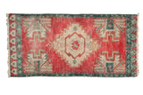 Distressed vintage Oushak rug, cherry red field, ivory medallion with potted floral motifs, aqua border.