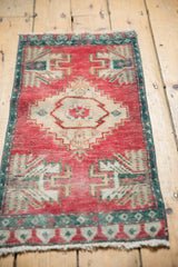 Distressed vintage Oushak rug with ivory stepped medallion, potted floral motifs, cherry red field.