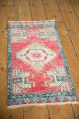 Distressed vintage Oushak rug detail: cherry red field, ivory stepped medallion, aqua border.