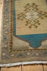 Distressed Oushak rug border showing off-white fringe and geometric design in muted tones.