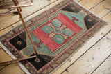 Distressed Oushak mat's low pile showcasing rose blush, aqua, and charcoal colors.