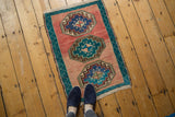 Nuanced blush abrashed field of a distressed Oushak rug with aqua blue gul medallions.