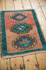 Detail of the central aqua blue and blush gul medallion on a distressed Oushak rug.