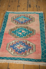 Vintage Oushak rug's distressed blush field with aqua gul medallions and a zigzag side border.