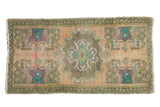 Distressed Oushak rug mat, scalloped center medallion with muted apricot, green, and purple. 1'8