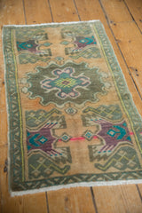 Distressed vintage Oushak rug's low pile texture, showcasing vibrant turquoise and purple motifs.