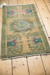 Distressed vintage Oushak rug with faded apricot beige, purple, and turquoise scalloped medallion.