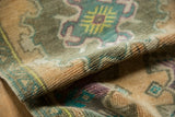 Distressed low pile of the Oushak rug with apricot beige, turquoise, and purple tones.