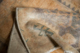 Distressed low pile texture and secured edge of Oushak rug with beige and mallard green.