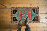 Vintage distressed Oushak rug, featuring 1981 dated quatafoil medallion in rose blush and aqua blue.