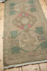 Distressed low pile with aqua green, bubble gum pink germinating plant motifs on vintage Oushak.