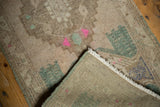 Vintage distressed Oushak rug, folded corner revealing low pile, reverse, aqua, pink motifs, fringe.