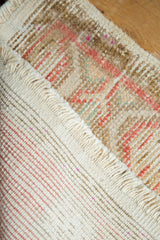 Distressed Oushak rug pile with blush and beige tones, visible foundation, and fringe.