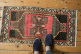 Vintage distressed Oushak rug mat featuring decorative faded pink and charcoal geometric patterns.