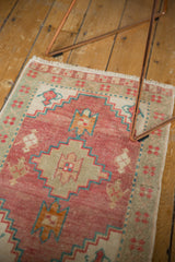 Distressed Oushak rug mat with softened pink, ivory, aqua, and seafoam geometric patterns.
