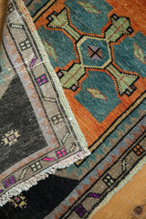 Distressed Oushak rug detail showing the dark woven foundation, fringe, and worn colorful pile.