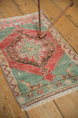 Distressed Oushak rug mat corner, seafoam green and cherry red geometric pattern.