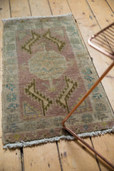 Oushak rug corner shows distressed pile, fringe, muted mauve, ivory, and dusty gold tones.