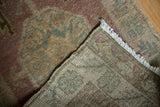 Distressed Oushak rug pile with even wear, hand-knotted reverse, and white fringe.