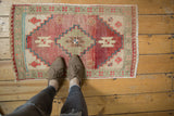 Vintage Oushak rug with stepped medallion on a heavily abrashed field in dusty rose and seafoam.
