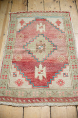 Vintage distressed Oushak rug, geometric stepped medallion, faded cochineal and seafoam.