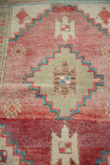Hand-knotted vintage Oushak rug close-up: abrash, cochineal, seafoam stepped geometric pattern.