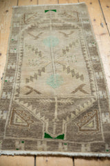 Angled view of distressed Oushak rug showing serrated leaves and germinating plant motif.