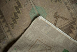 Vintage Distressed Oushak rug corner showing beige foundation, neutral fringe, and pile texture.