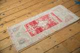 Distressed vintage Turkish Oushak rug with faded red field and pale pink, teal motifs.