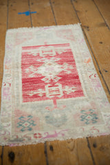 Distressed Oushak rug with soft, low pile, faded cherry red field, and short fringed end.