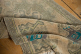 Vintage distressed Oushak rug pile with soft apricot beige, dusty silver, and turquoise hues.